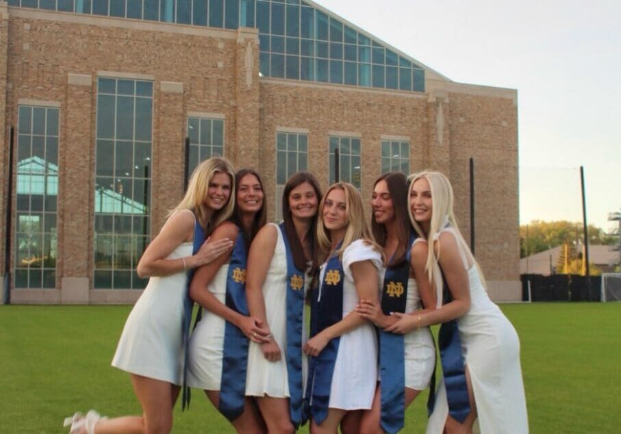 Six women in white graduation dresses.